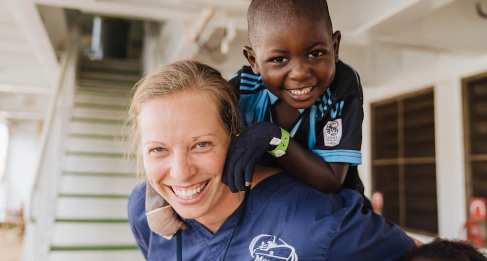 Volunteer nurse with child smiling